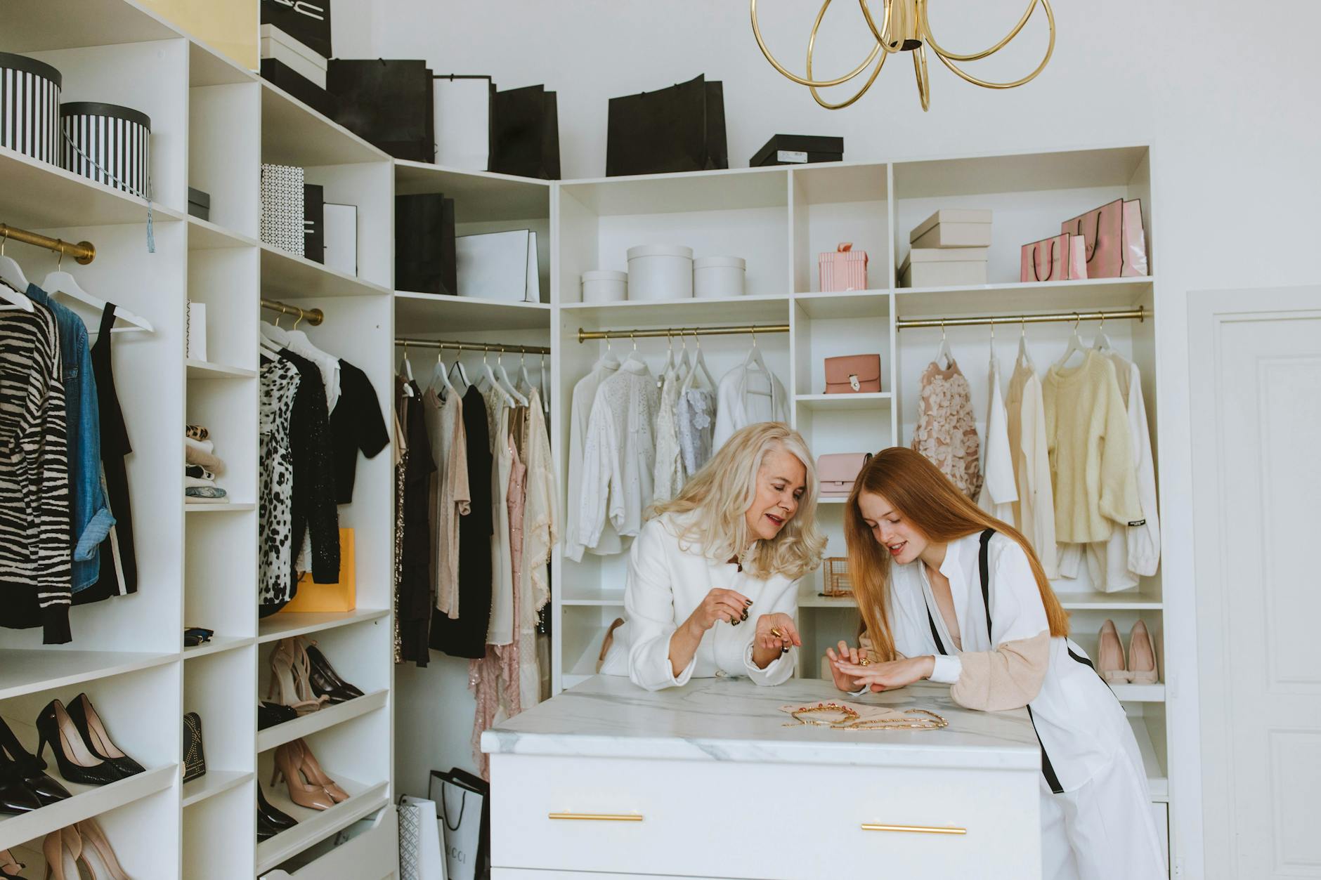 Dwie eleganckie kobiety oglądają ubrania w luksusowej garderobie