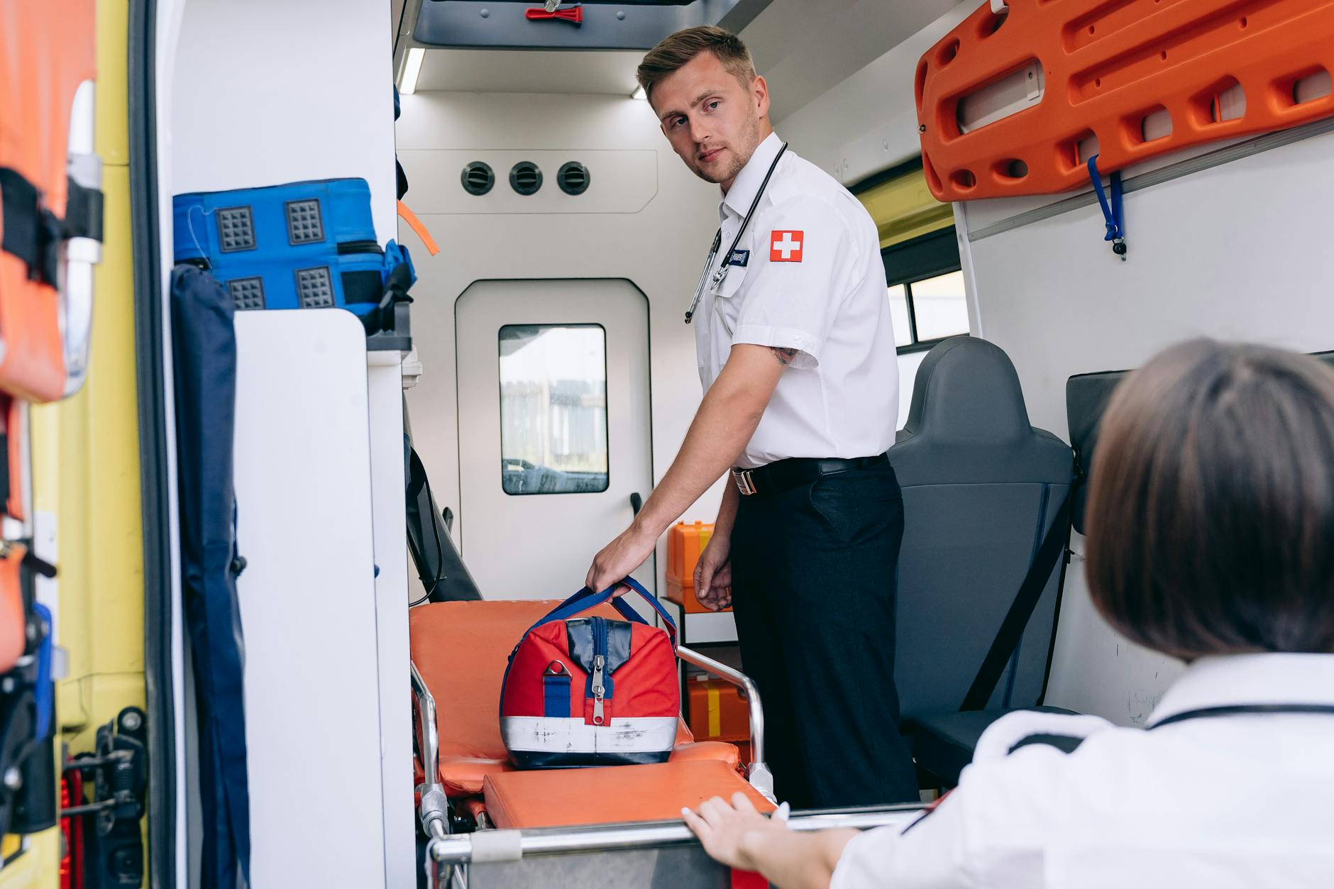 Ratownik medyczny porządkuje apteczkę w karetce przed akcją ratunkową